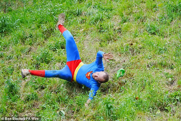 One cheese pursuer in a Superman costume was among those toppling down the steep incline