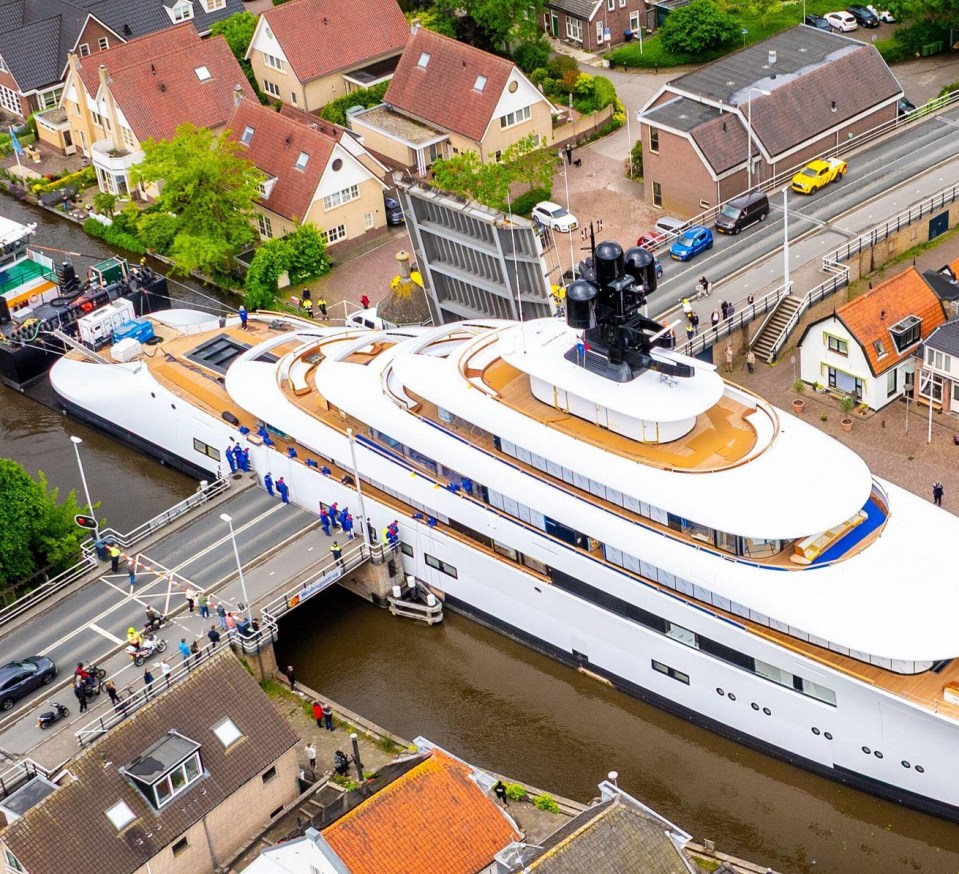 Aerial view of a large yacht passing through a canal.