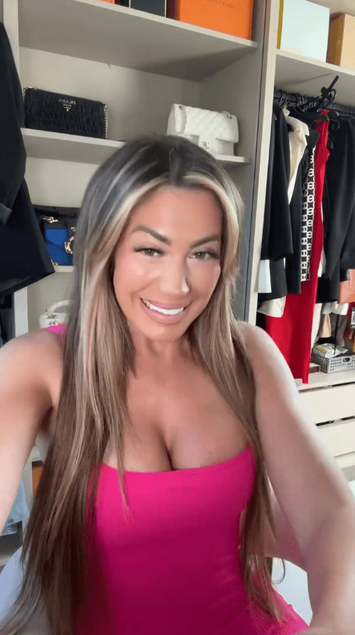 Woman in pink dress in front of closet.