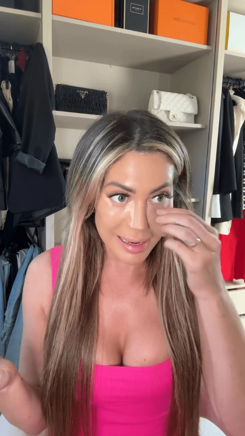 Woman applying makeup, demonstrating contouring technique.