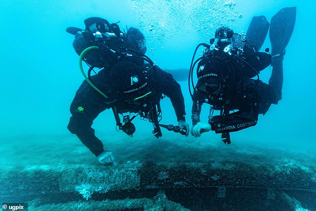 Italian coastguard divers check their pressure gauges - at 150ft below sea level they can only spend around ten minutes examining the wreck of the Bayesian