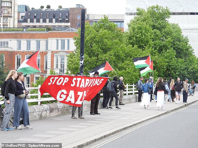 Activists wearing keffiyehs over their faces clanged metal saucepan lids and shouted from megaphones on Waterloo Bridge on Sunday morning