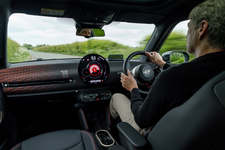 Person driving a Mini Cooper.
