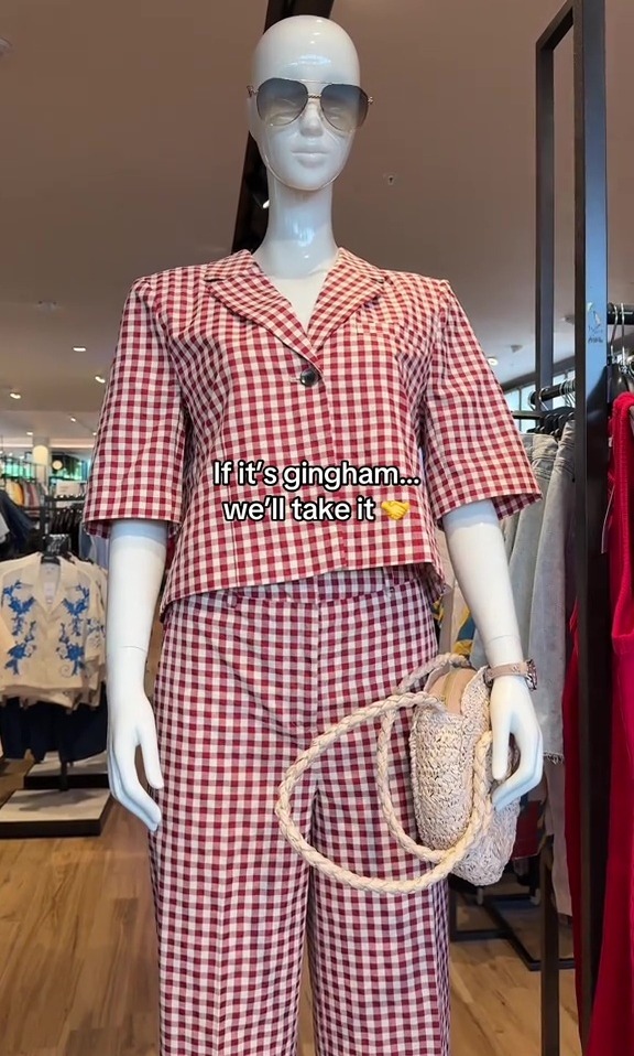 Mannequin wearing a red and white gingham pantsuit and sunglasses.