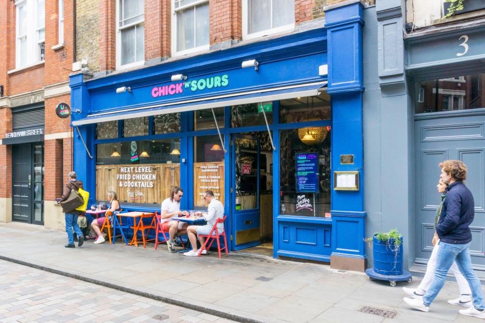 People sitting outside Chick 'n' Sours restaurant in London.