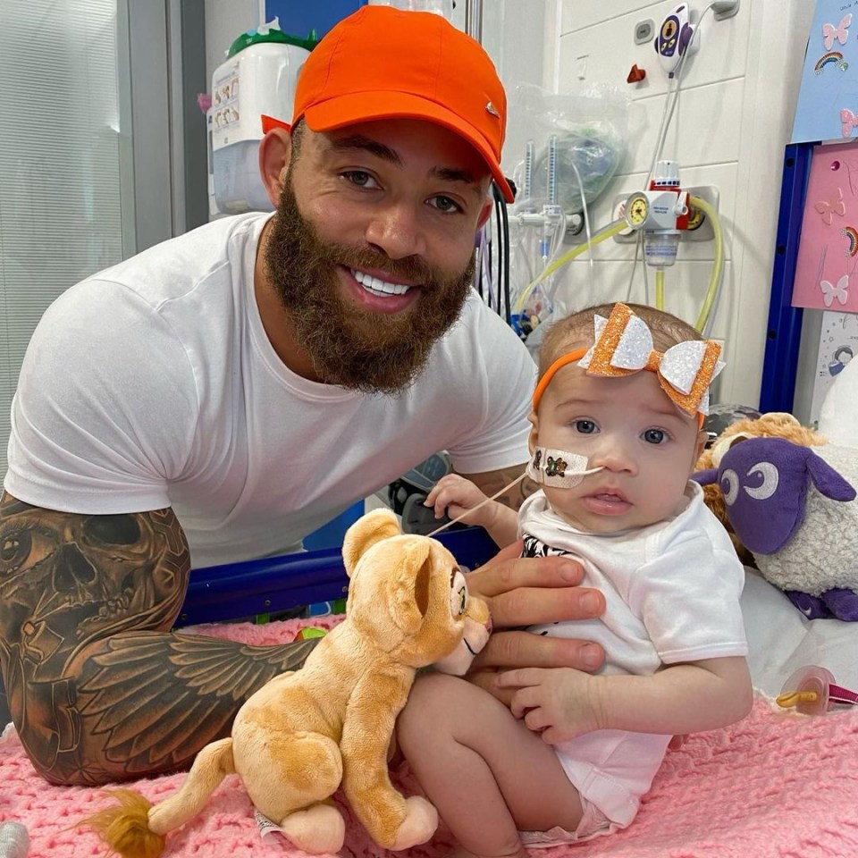 A father and his baby daughter in a hospital room.