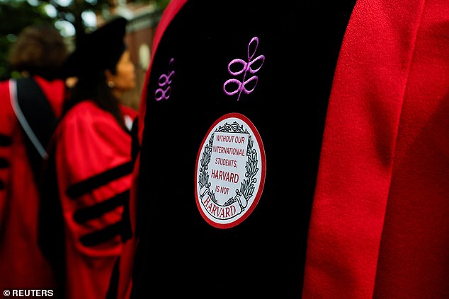 An attendee at Harvard University's commencement on Thursday wears a sticker that reads 'without our international students, Harvard is not Harvard'