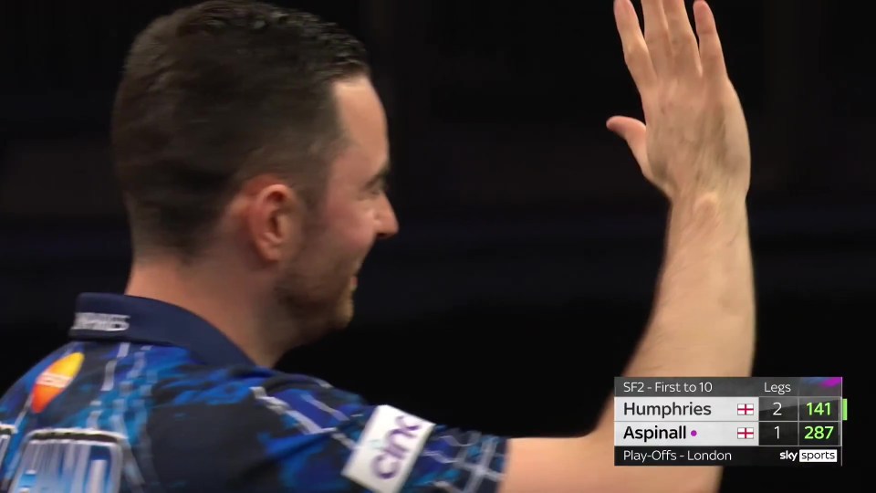 Luke Humphries waves to the crowd after a darts match.