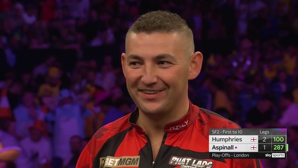 Luke Humphries smiles after a darts match.