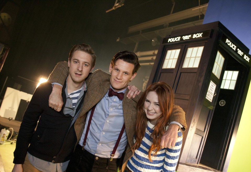 Three actors from the TV show *Doctor Who* posing together in front of the TARDIS.
