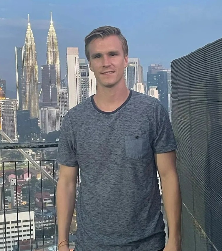 Man standing on a balcony overlooking Kuala Lumpur.