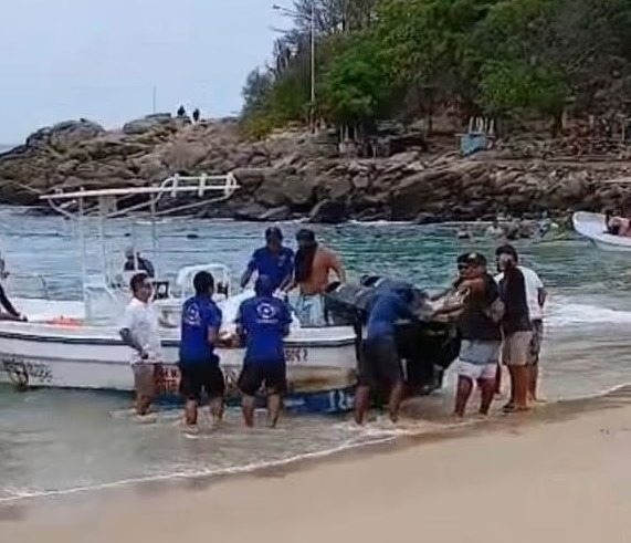 People carrying something large from a boat to the shore.