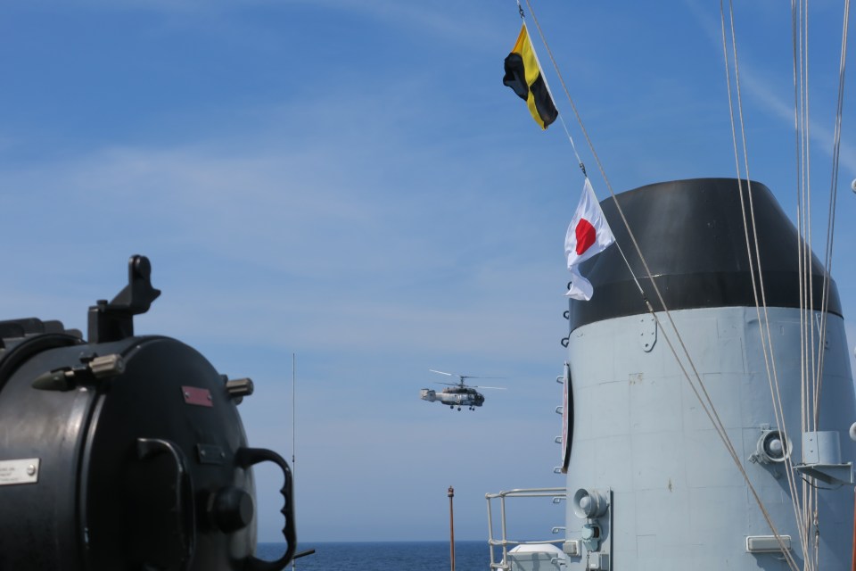 Merlin helicopter over Royal Navy ship.