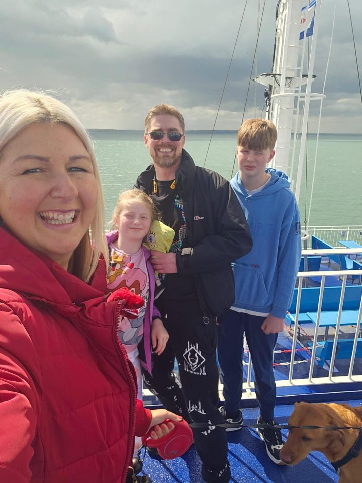 Family on a ferry with their dog.