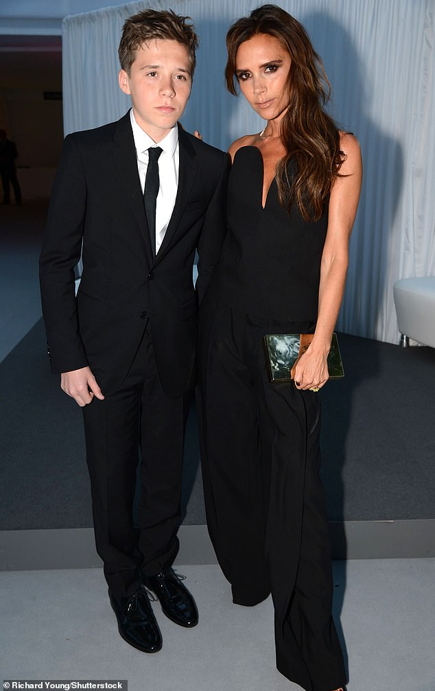 Brooklyn previously said of his childhood: 'We were always doing something. But, I have the best mum and dad in the world and it was a lot of fun' (pictured age 14 with Victoria in 2013)