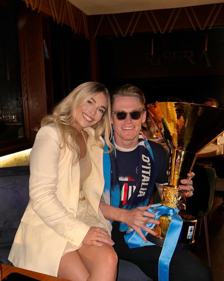 Couple posing with a trophy.
