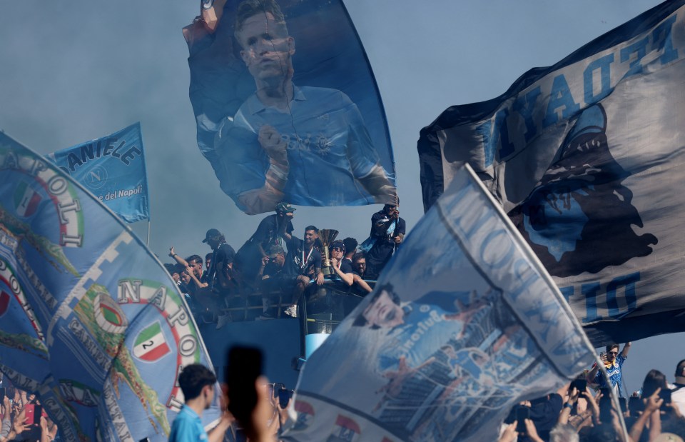 Napoli's Scott McTominay and Matteo Politano celebrating on a victory parade bus.