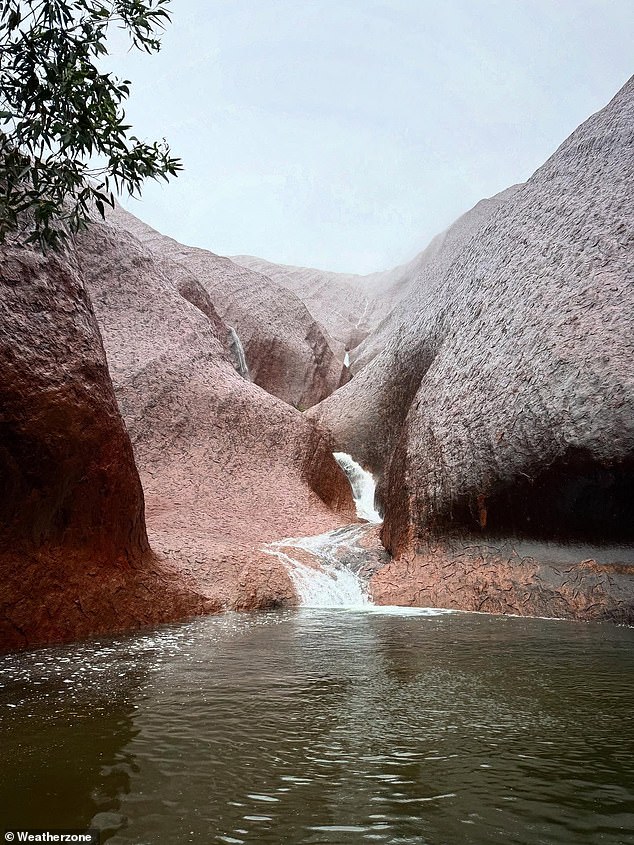 Mutitjulu waterhole at Uluru turned into a picturesque waterfall on Sunday after a drenching at Australia's typically arid red centre