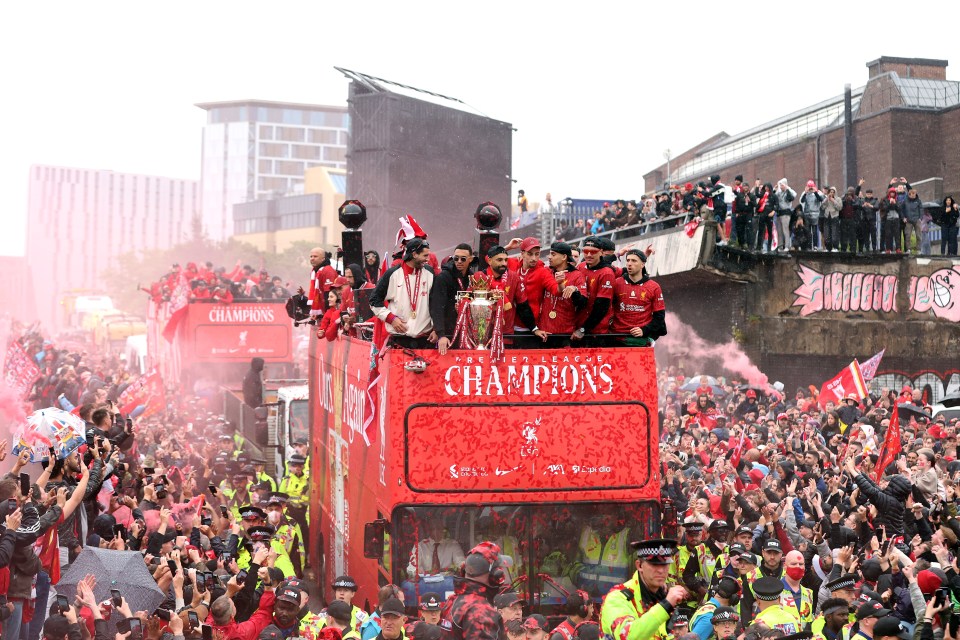 Liverpool players celebrating on a bus during a Premier League trophy parade.