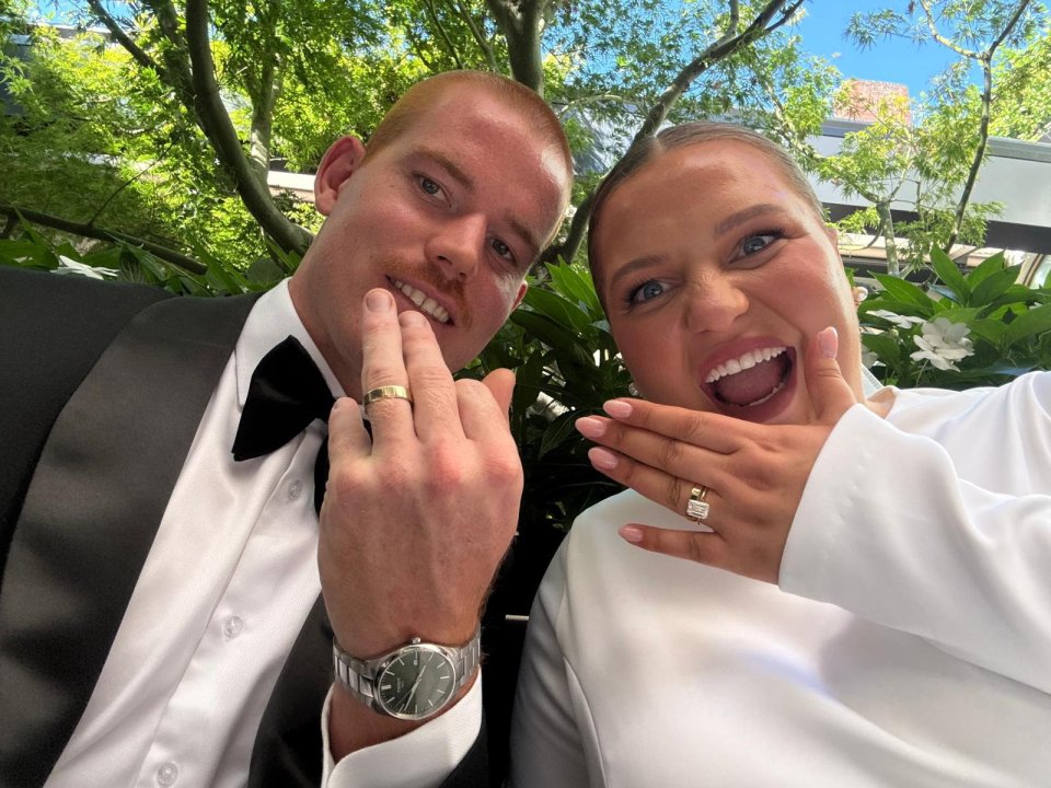 Newlywed couple showing off their wedding rings.