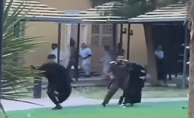 A woman is seen trying to flee before she is thrown to the ground and beaten