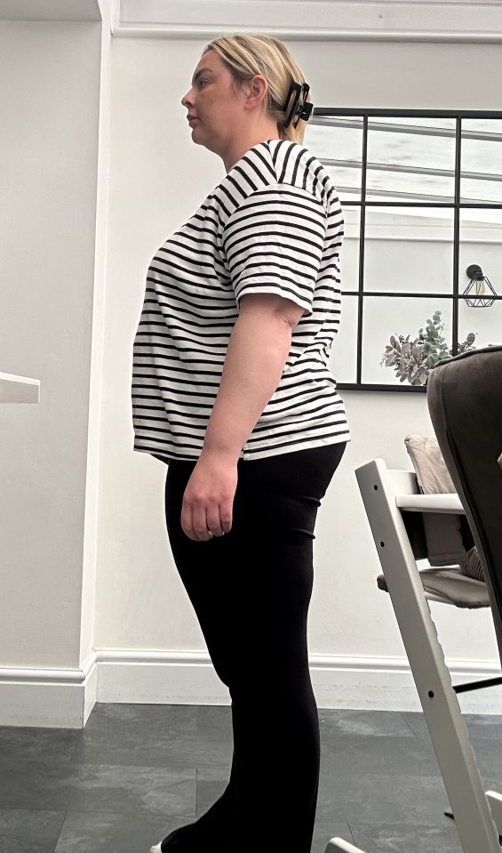 Woman in striped shirt and black pants, side profile.