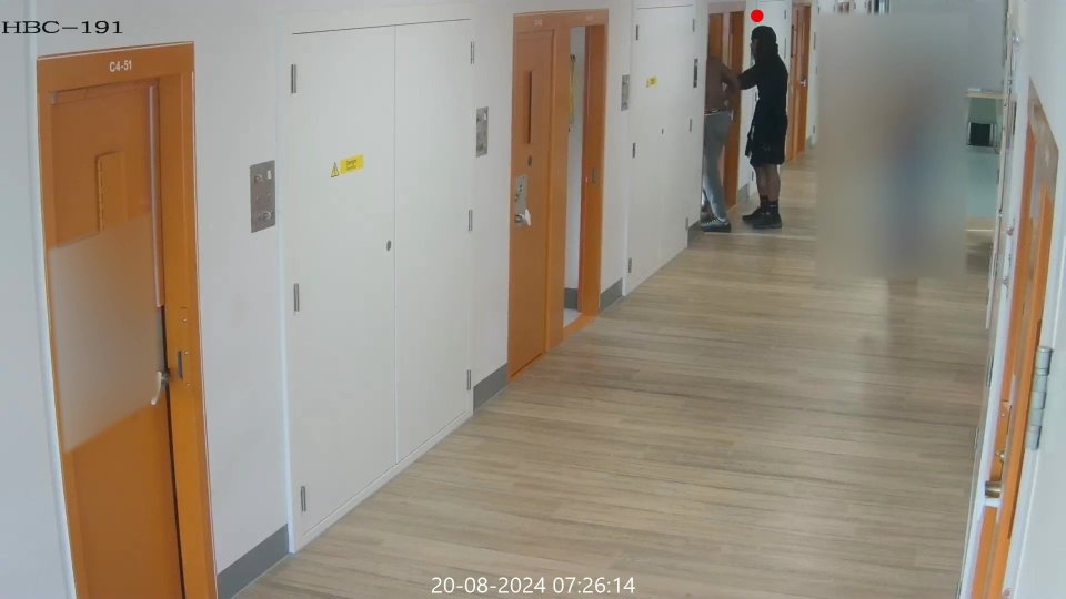 CCTV footage of a prison hallway showing a prisoner leaving a cell after an assault.