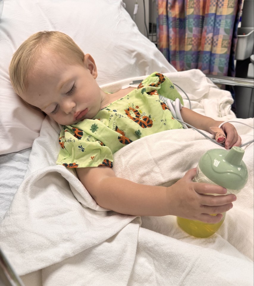 Toddler sleeping in a hospital bed with an IV.