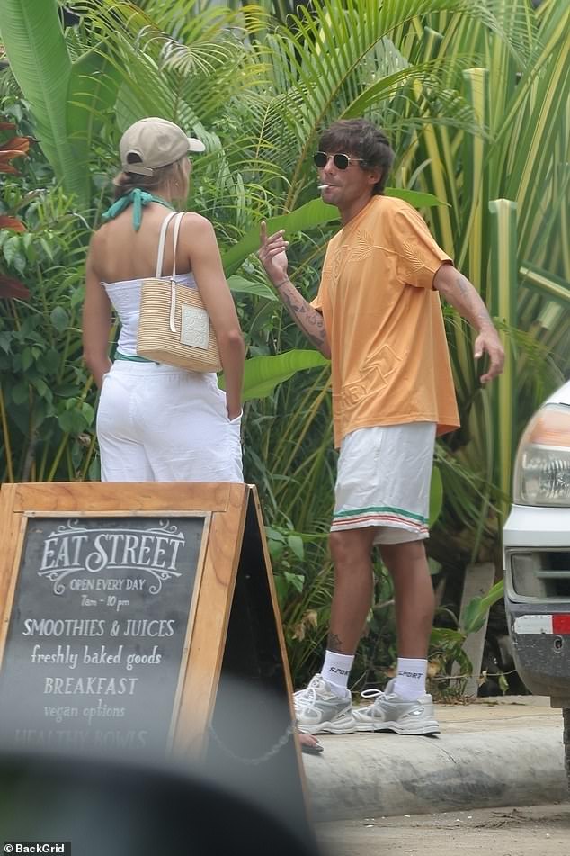 looked stylish in an orange Burberry T-shirt, white shorts and trainers