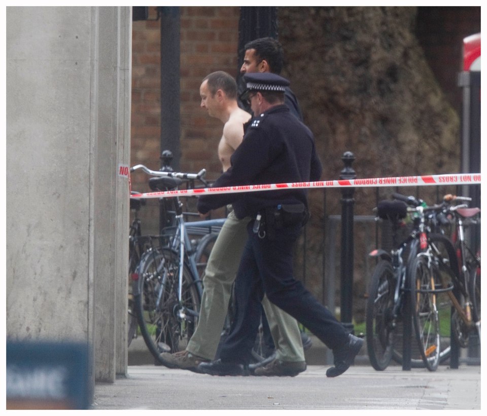 A man being led away by police.