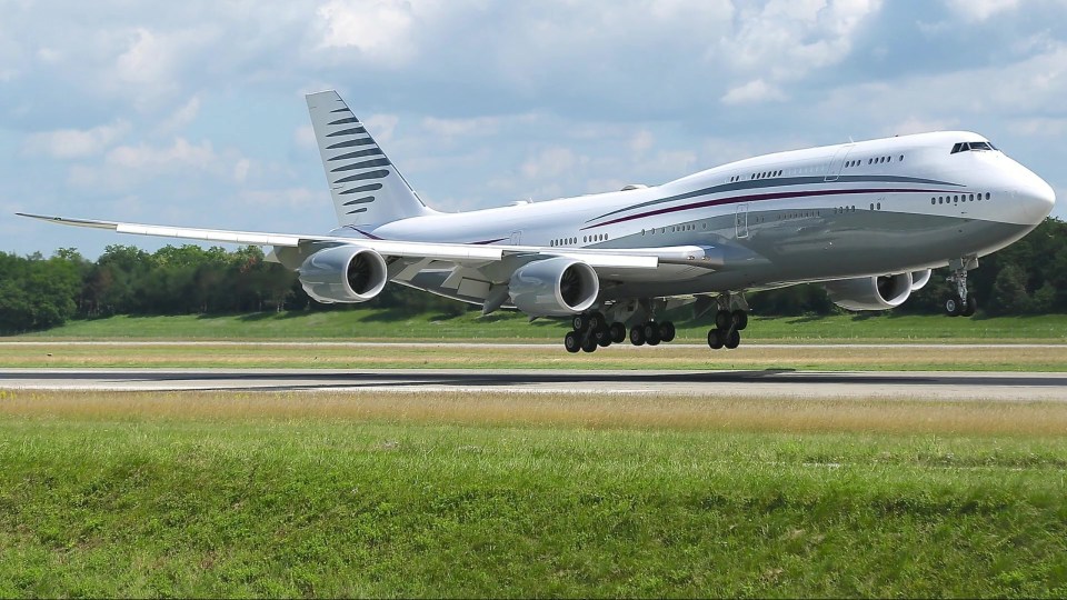 Large private jet landing on a runway.