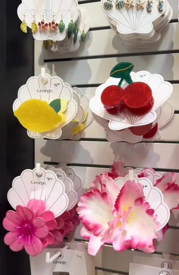 Assortment of fruit-shaped hair clips and earrings displayed on a shelf.