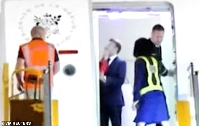 Brigitte Macron's arms - in red - were seen reaching out and pushing Macron away, with one hand covering his mouth and part of his nose while the other was on his jaw