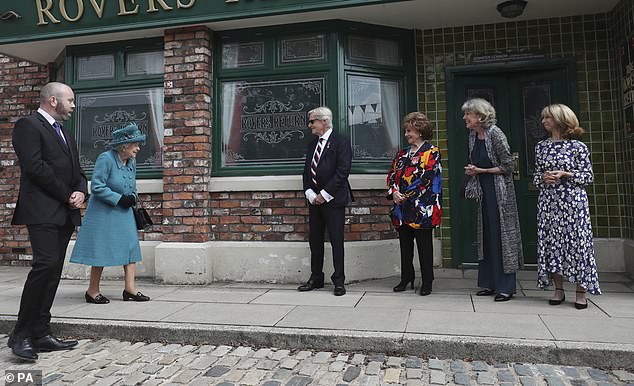 Her Late Majesty was even presented with 'Coronation Street gin', handed to her during a tour of the famous TV street (pictured)