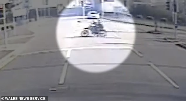 The bike seen zooming from a side street, across an island of traffic lights and onto a main road
