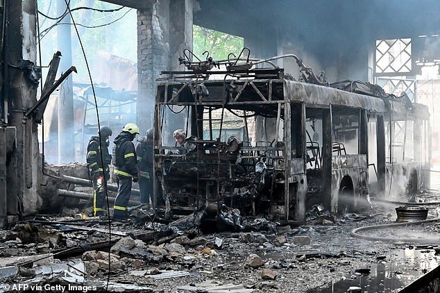 Ukrainian rescuers work to extinguish a fire in a trolleybus depot following a drone strike in Kharkiv