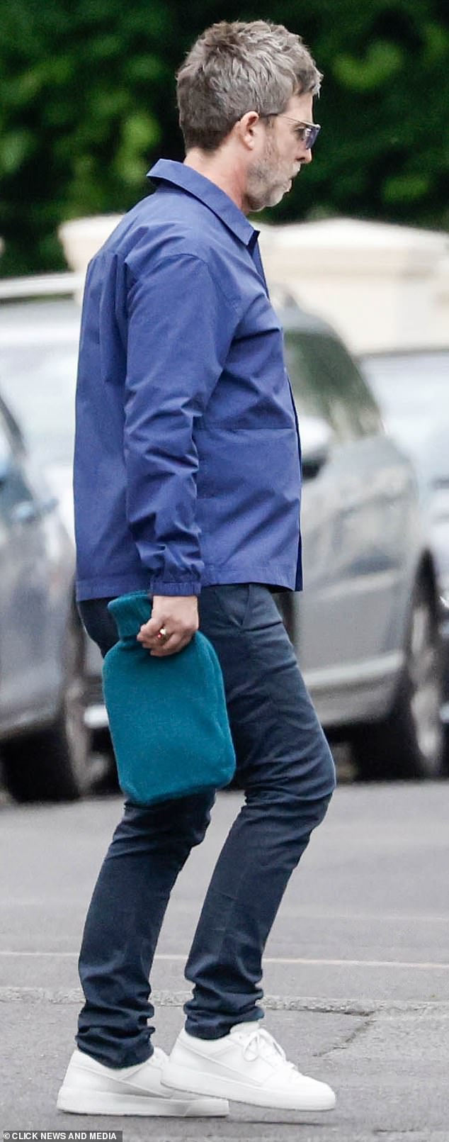 Noel at a recent rehearsal session sans Liam... but with a hot water bottle for his aching back