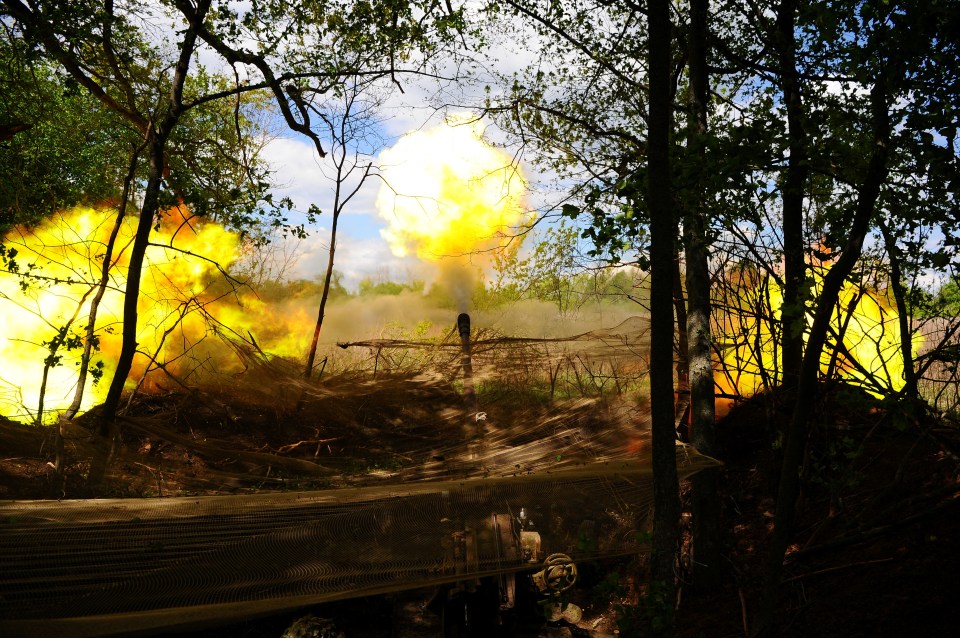 Ukrainian servicemen firing a howitzer.