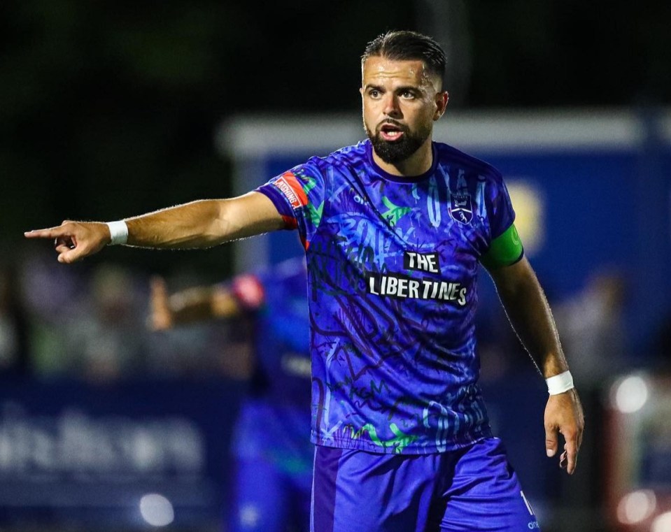 Soccer player in a purple jersey directing the game.