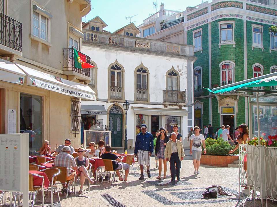 Lagos town square with people at cafes and shops.