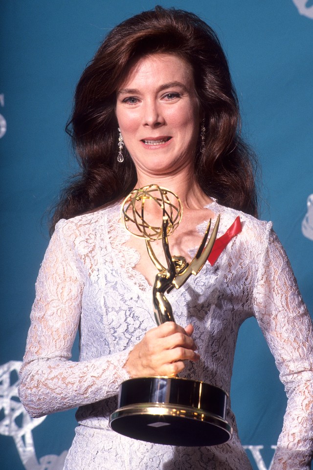 Valerie Mahaffey holding an Emmy award.