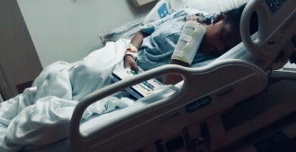 a person is laying in a hospital bed with a bandage on their arm .