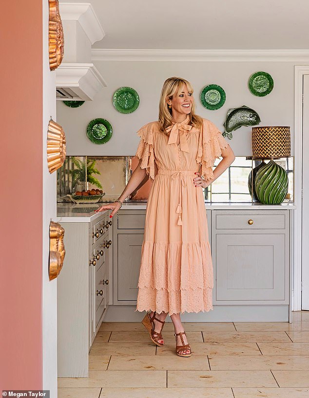 Francesca in her kitchen. The cabbage and fish plates were collected over years from antique markets in the UK and France. Dress, houseofdisgrace.co.uk. Sandals, dunelm.com