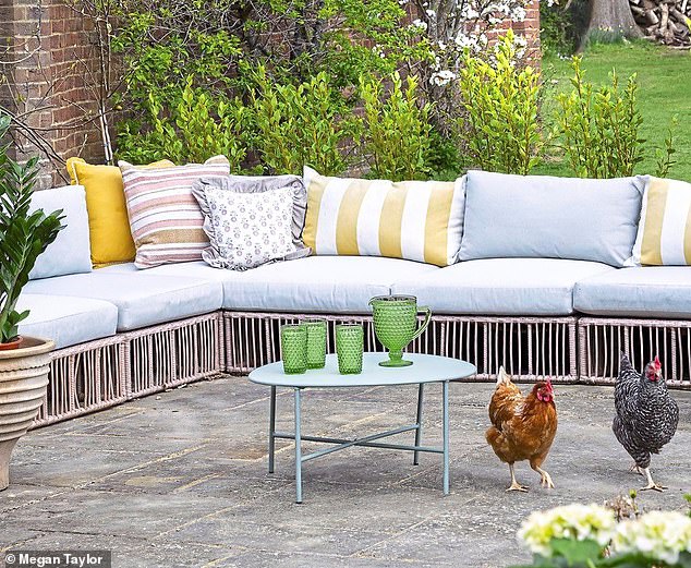 Pet chickens roam freely in the garden. The sofa is from made.com. For a range of outdoor tables try grahamandgreen.co.uk.