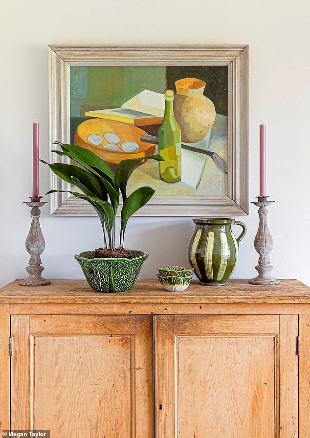 Francesca inherited this wooden cabinet from her parents: ‘It was their old record cupboard,’ she says. ‘Now it houses crockery and linens. The artwork is from Ardingly Antiques Fair.’