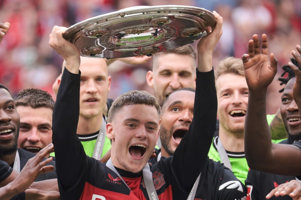 Florian Wirtz of Bayer Leverkusen lifts the Bundesliga championship trophy.