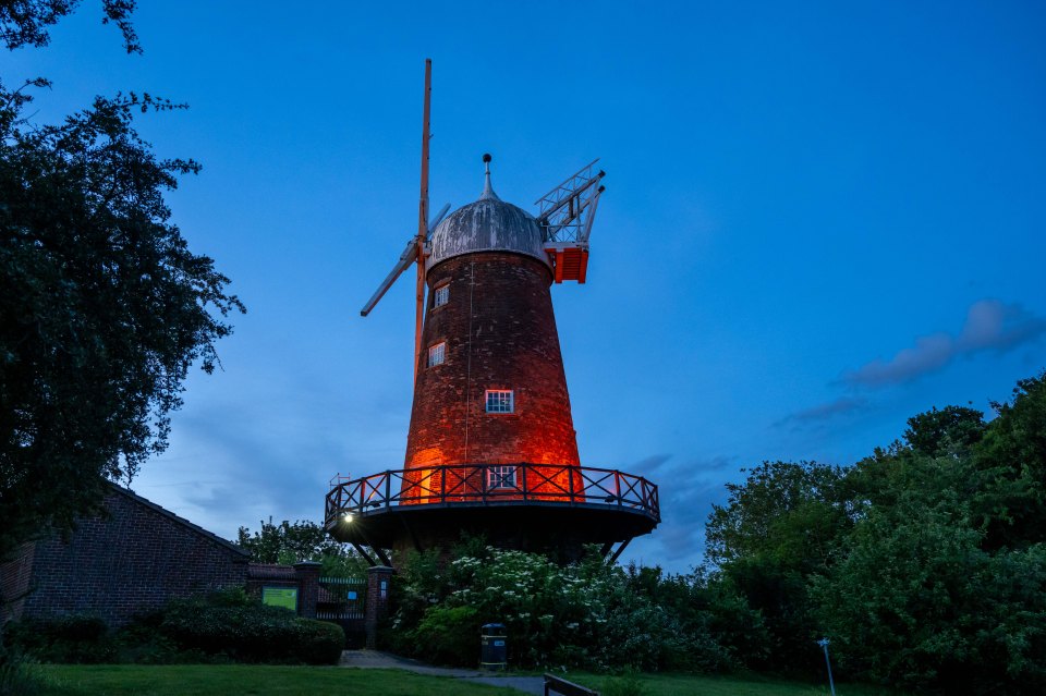 Orange-lit windmill at dusk.