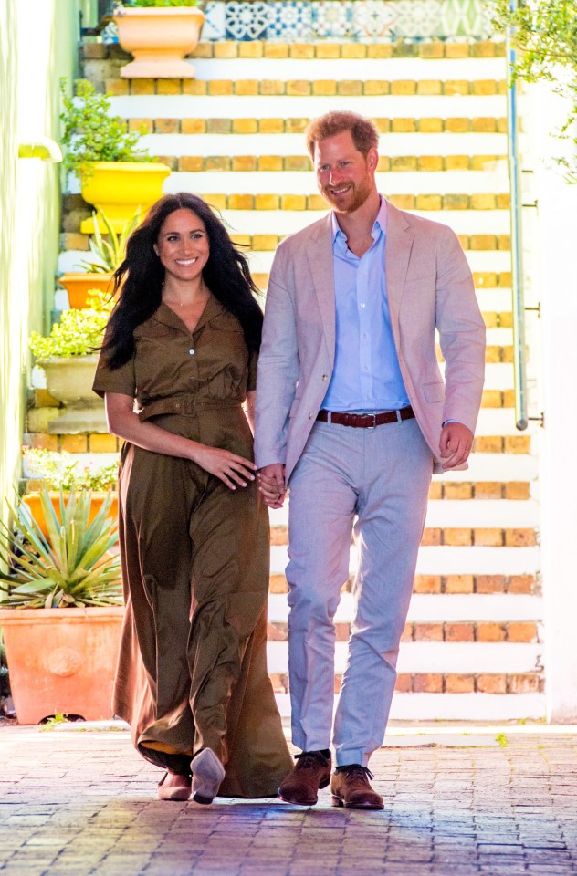 Prince Harry and Meghan Markle walking hand-in-hand.