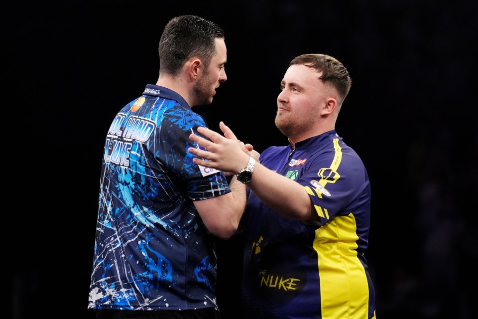 Luke Humphries embracing Luke Littler after a darts match victory.