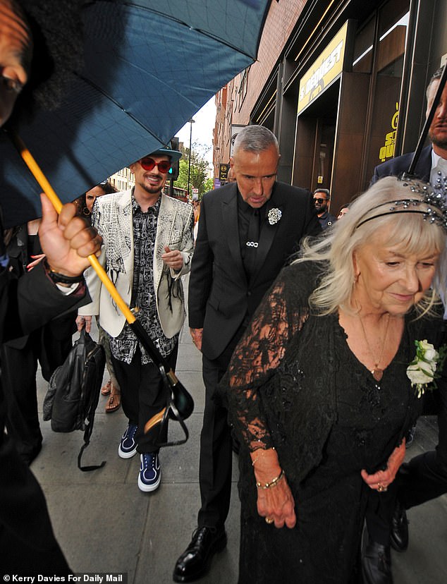 The renowned music star, real name Tony Marnach, cut a very dapper figure in an all-black suit featuring a silver brooch (pictured with Dawn and Boy George)